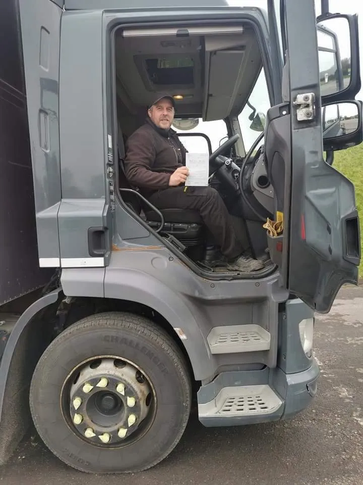 A man sitting in the driver's seat of a truck.
