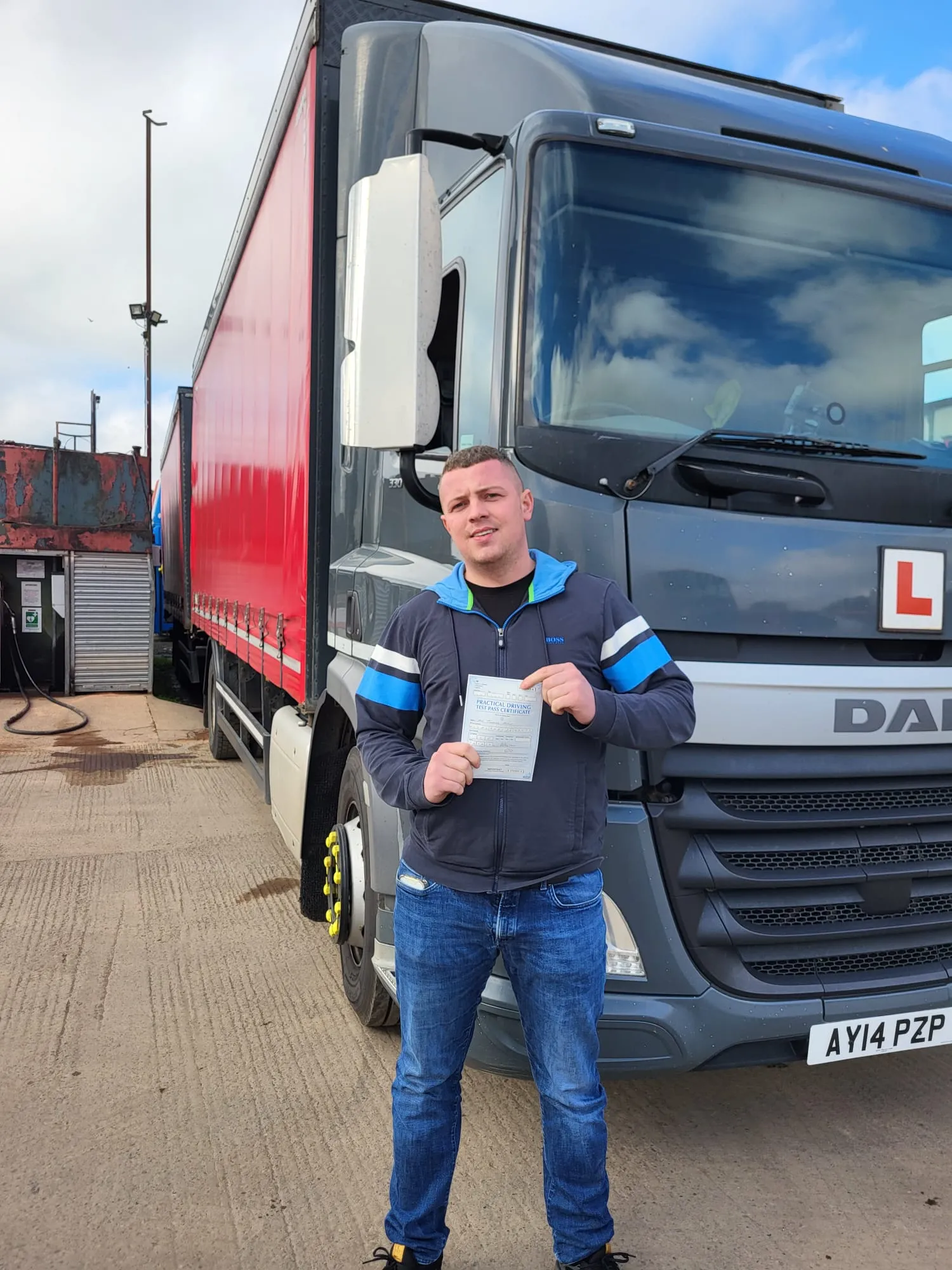 A man standing in front of a truck holding a piece of paper.