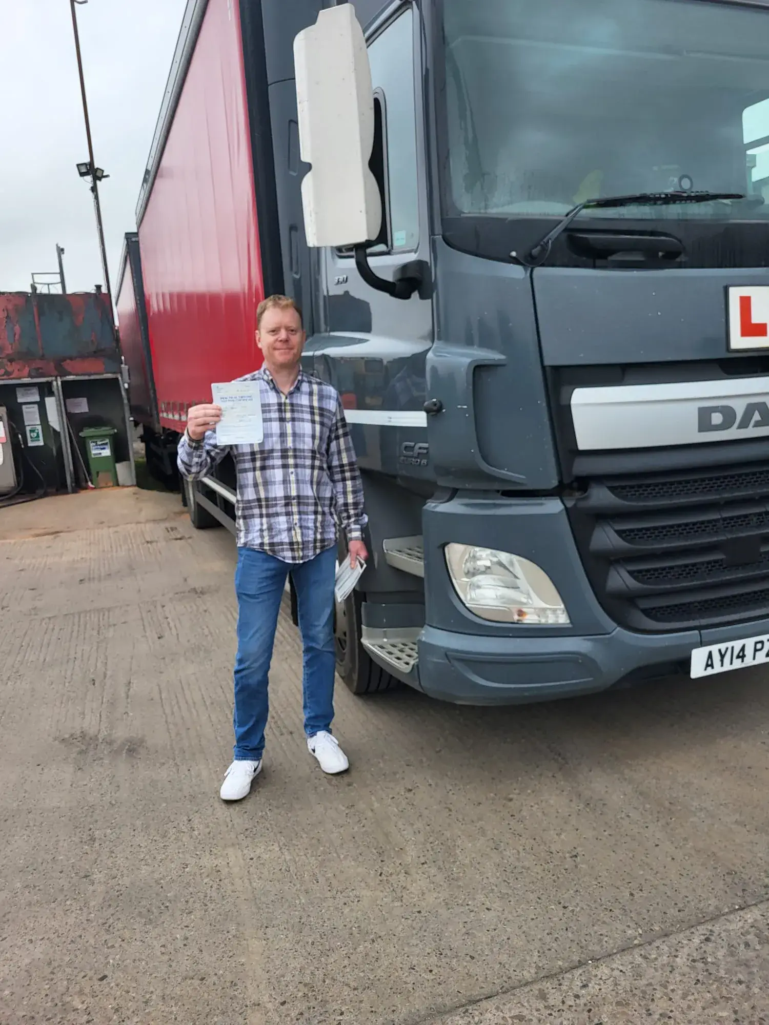 A man standing next to a large truck.